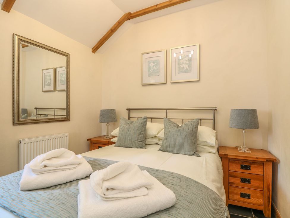 A bedroom with a bed and bedside tables at Beech Cottage in Truro