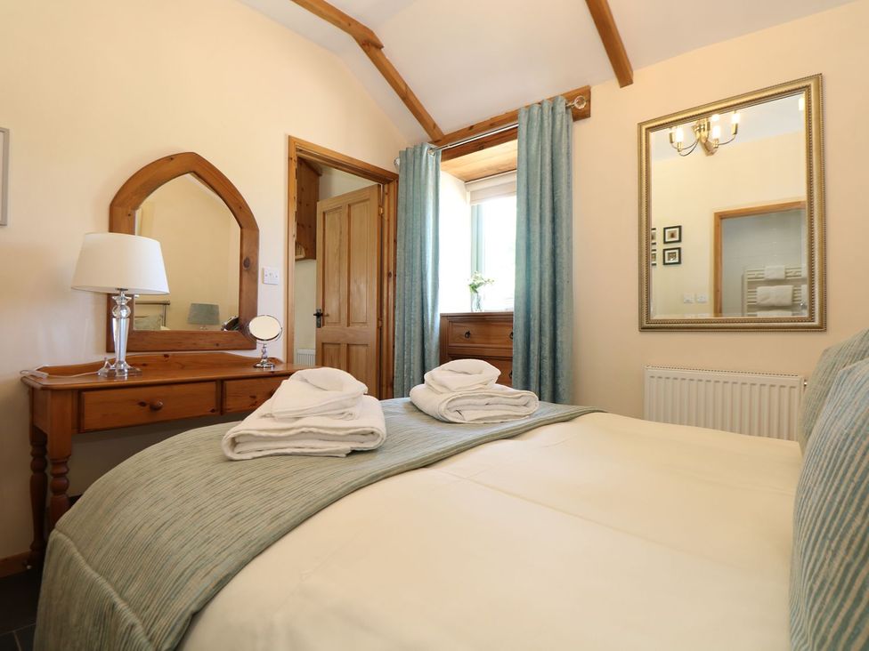 A bedroom with a bed and a dressing table at Beech Cottage in Truro