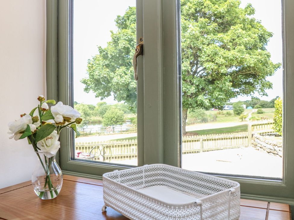 A window with a flower vase and basket at Beech Cottage in Truro