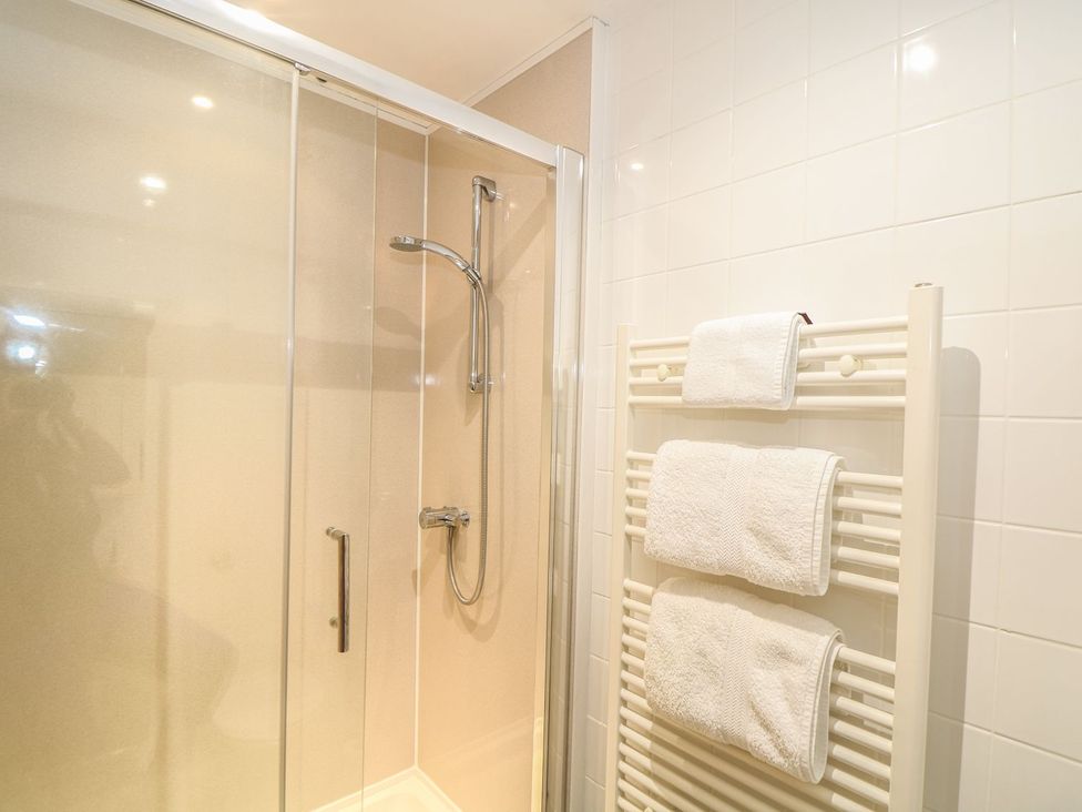 A bathroom with a shower and towel rack at Beech Cottage Truro