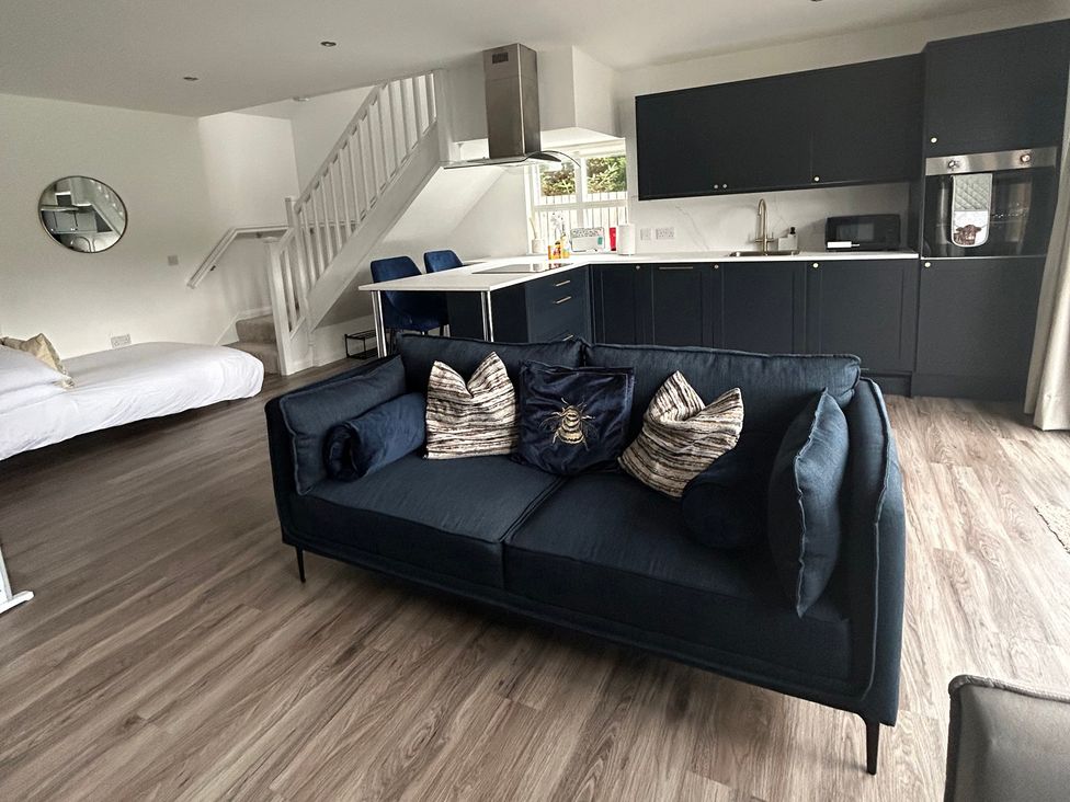 A living room with a sofa and dining area at Broomfield Hideaway near Inverness