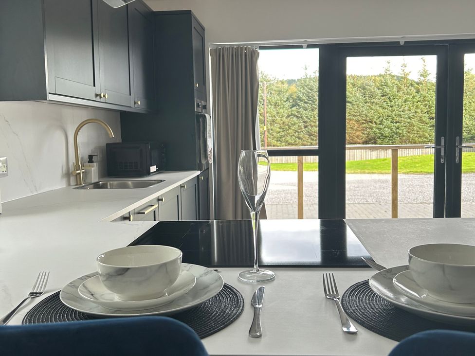 A kitchen with a table set for dining at Broomfield Hideaway near Inverness