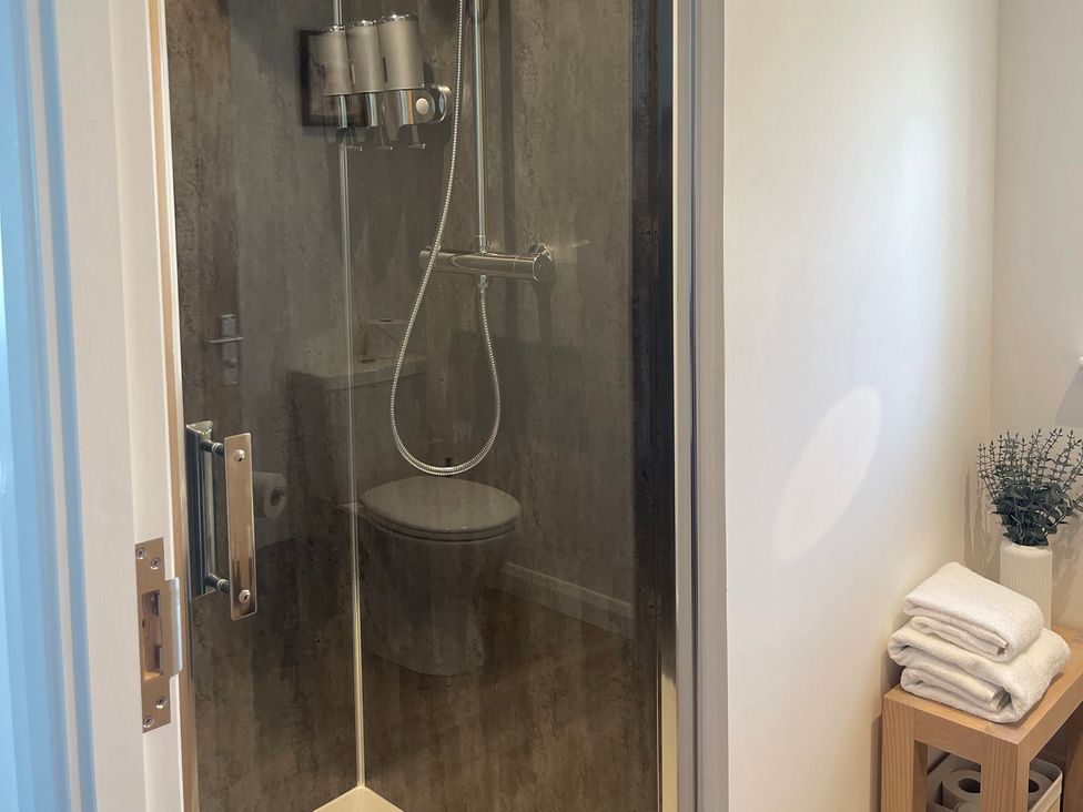 A bathroom with a shower, toilet, and towels at Broomfield Hideaway near Inverness