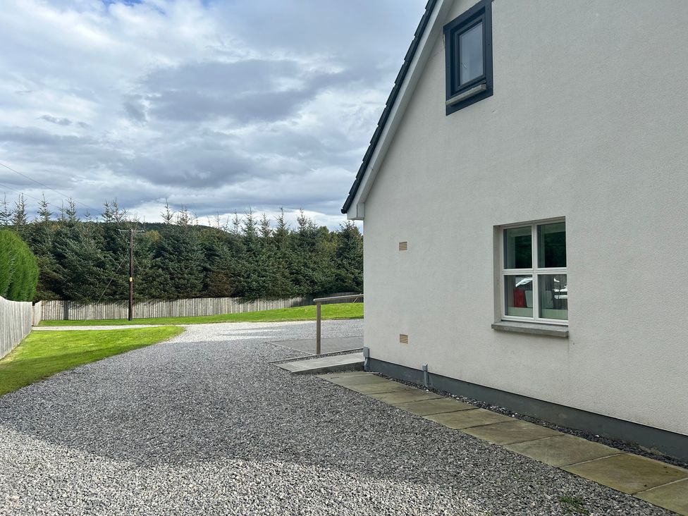 The exterior of a house with a gravel driveway and a lawn at Broomfield Hideaway near Inverness