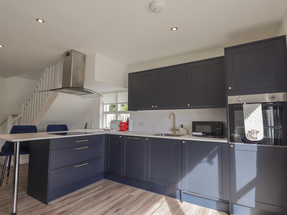 A kitchen with dark cabinets and a sink at Broomfield Hideaway near Inverness