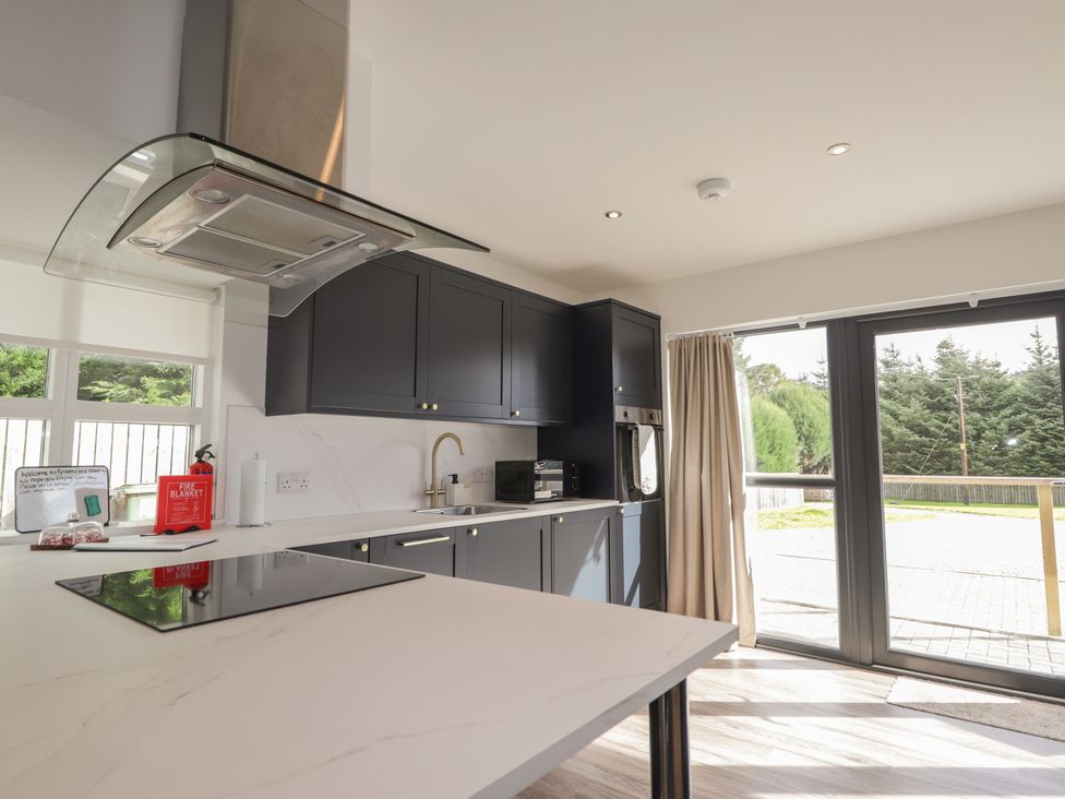 A kitchen with cabinets and appliances at Broomfield Hideaway near Inverness