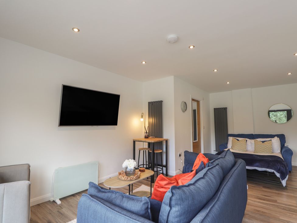 A living room with a television and seating at Broomfield Hideaway near Inverness