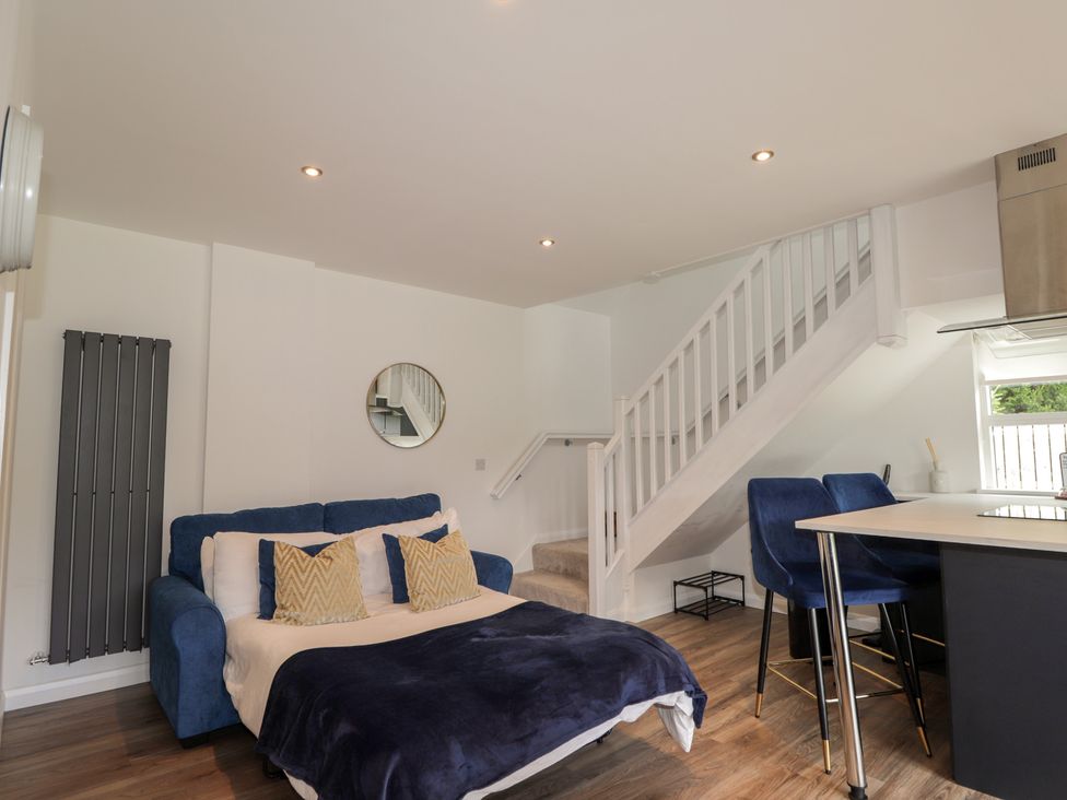 A living room with a sofa and staircase at Broomfield Hideaway near Inverness