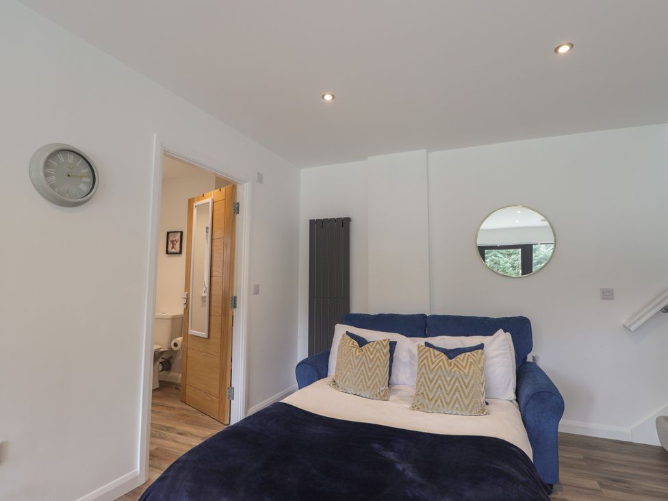 A bedroom with a bed and a mirror at Broomfield Hideaway near Inverness