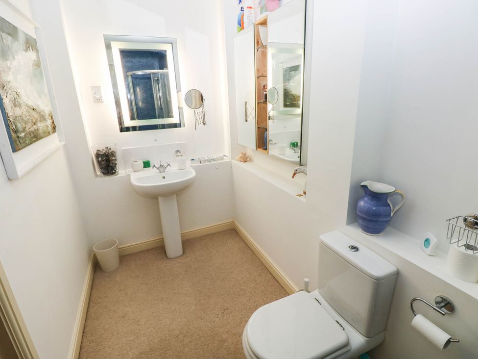 A bathroom with a sink and toilet at Basement Apartment in Tenby