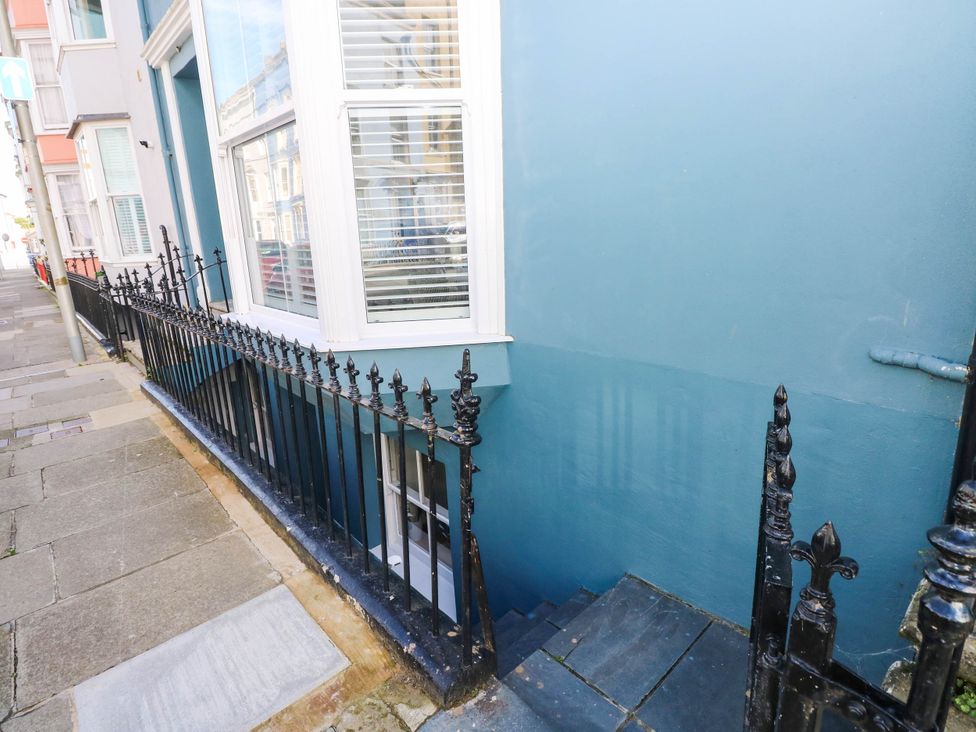 A stairway with railing outside a building at Basement Apartment in Tenby