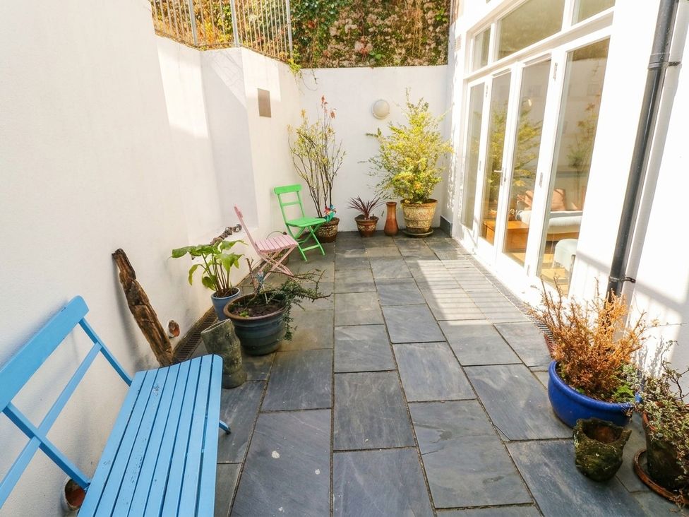 An outdoor space with benches and potted plants at Basement Apartment in Tenby