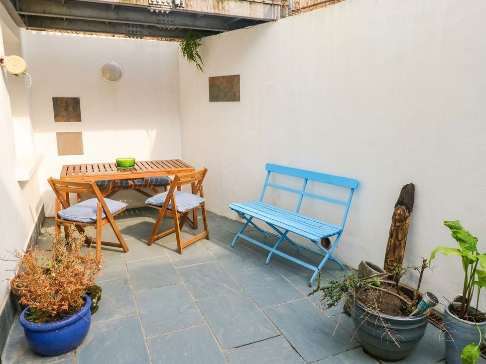 An outdoor area with a table and chairs at Basement Apartment in Tenby
