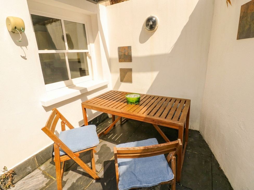 A table with two chairs in an outdoor area at Basement Apartment in Tenby