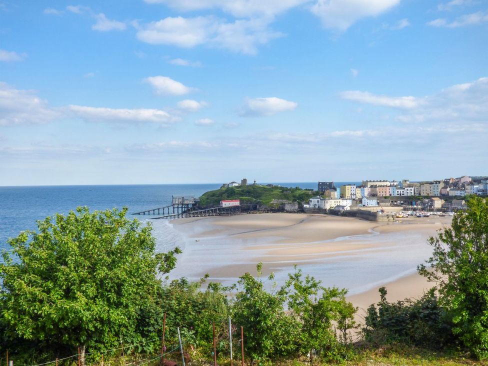 A view of a coastal area with a beach and pier at Basement Apartment in Tenby