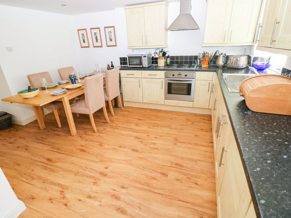 A kitchen with dining table and chairs at Basement Apartment in Tenby