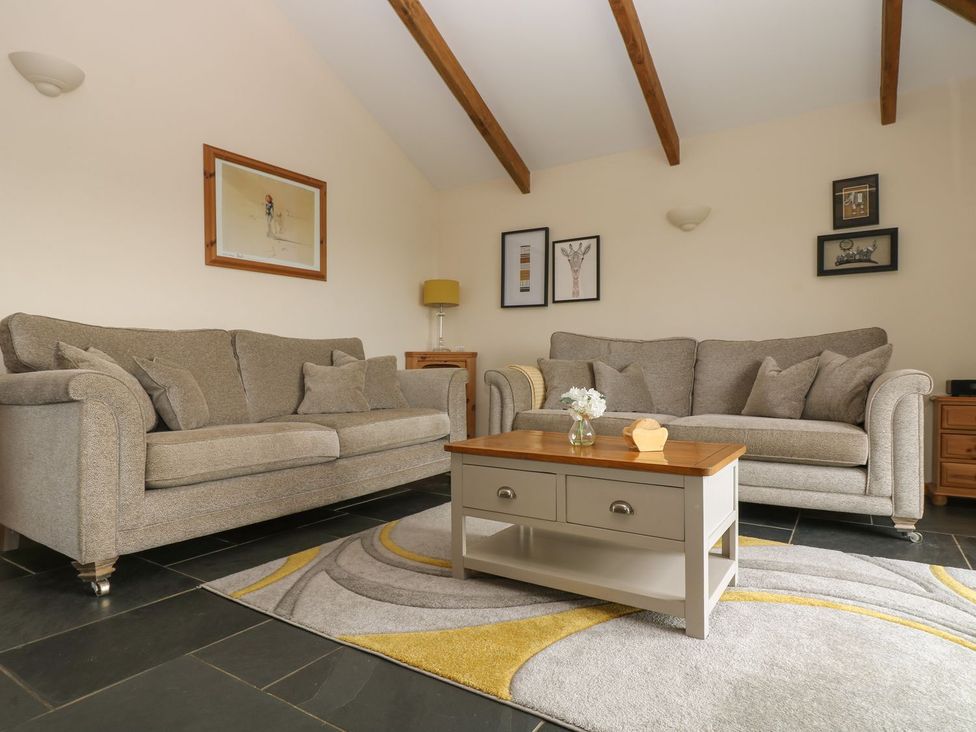 A living room with a sofa and table at Hawthorn Cottage in Truro