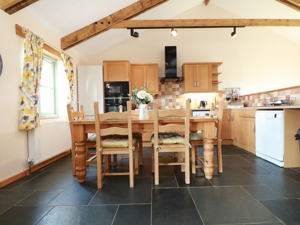 A kitchen with dining table and appliances at Hawthorn Cottage in Truro