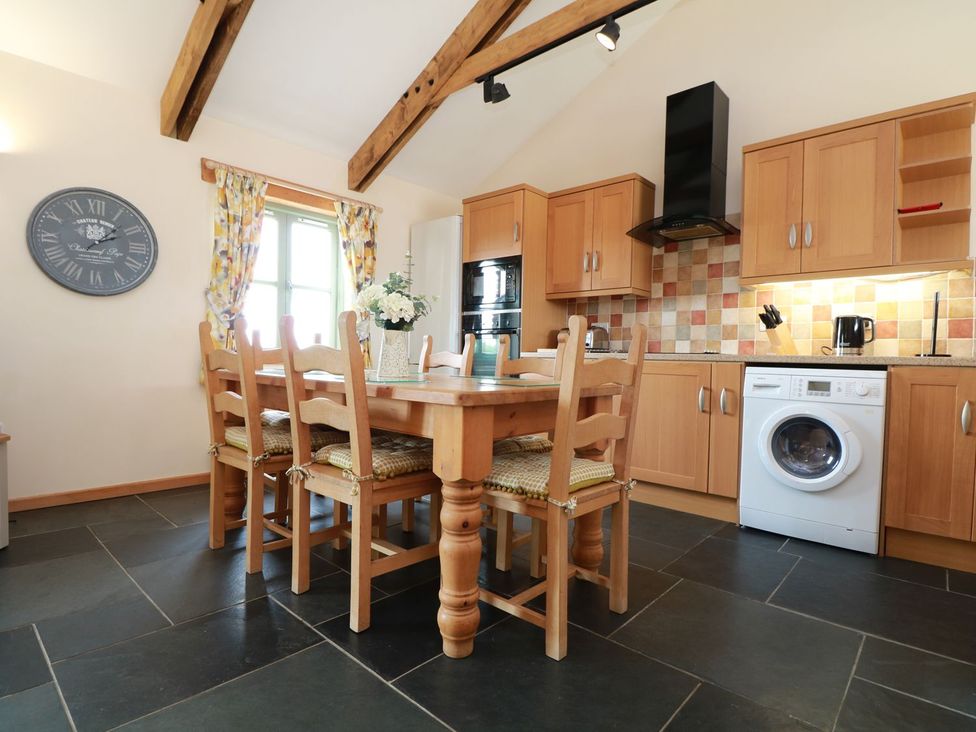 A kitchen with a dining table and appliances at Hawthorn Cottage in Truro