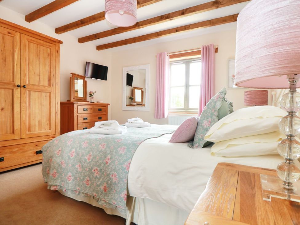 A bedroom with a bed and wardrobe at Hawthorn Cottage in Truro
