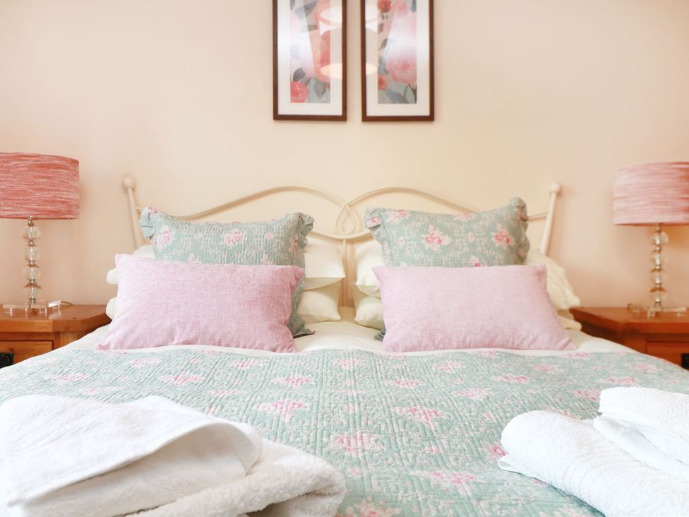 A bedroom with a bed and lamps at Hawthorn Cottage in Truro