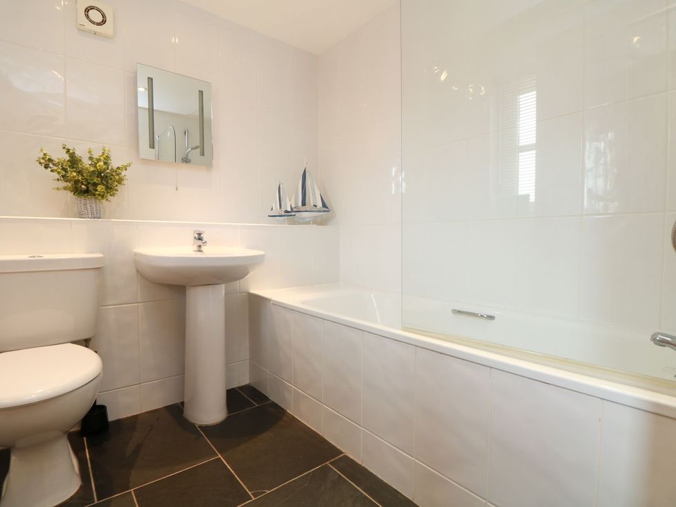 A bathroom with a sink, toilet, and bathtub at Hawthorn Cottage in Truro