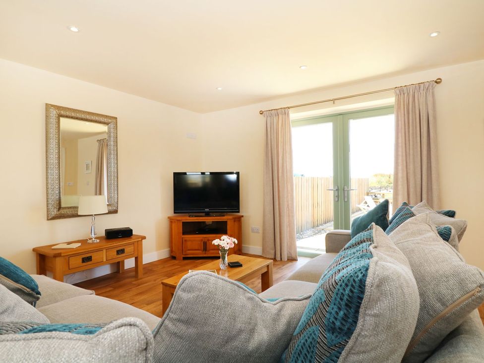 A living room with a sofa and television at Elm Cottage in Truro
