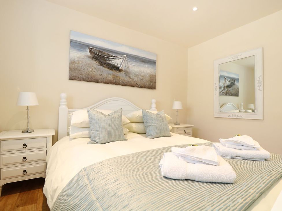 A bedroom with a bed and bedside tables at Elm Cottage in Truro