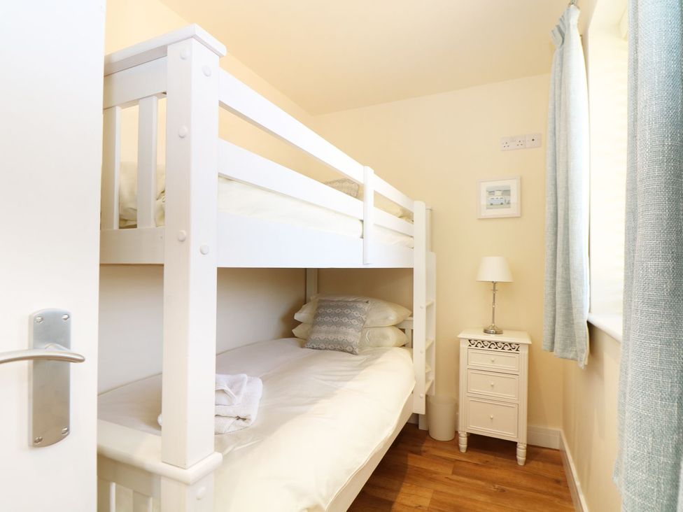 A bedroom with a bunk bed and bedside table at Elm Cottage in Truro