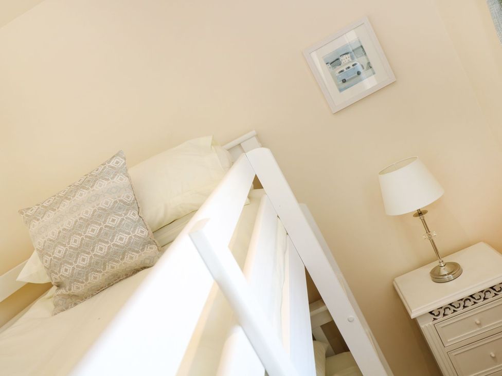 A bedroom with a bed and side table at Elm Cottage in Truro