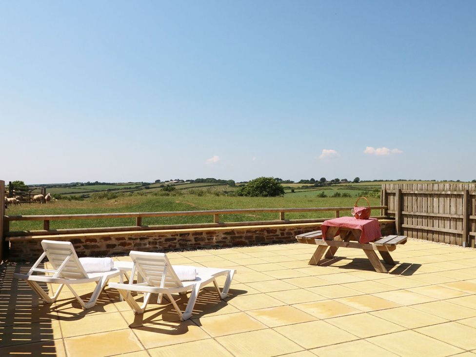 An outdoor area with deck chairs and a picnic table at Elm Cottage in Truro