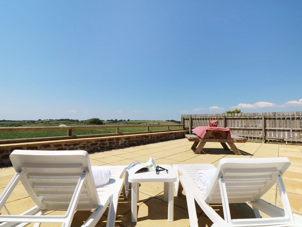 An outdoor area with sun loungers and a table at Elm Cottage in Truro