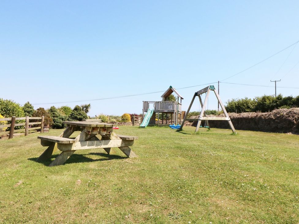 A garden with a picnic table and play equipment at Elm Cottage in Truro