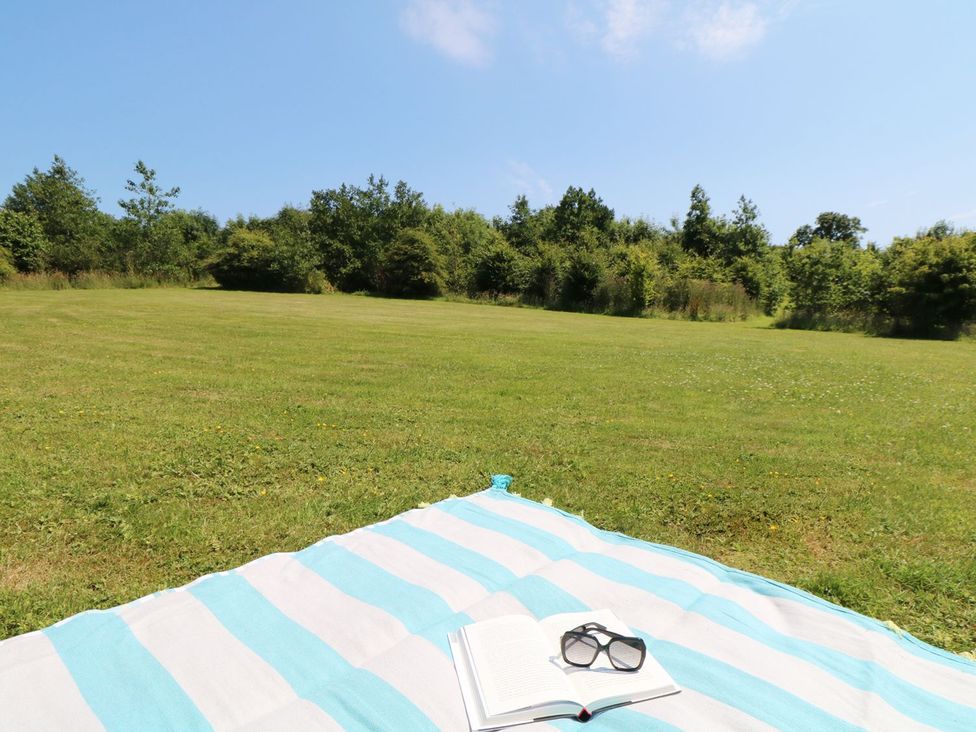 A blanket with a book and sunglasses in an outdoor area at Elm Cottage in Truro