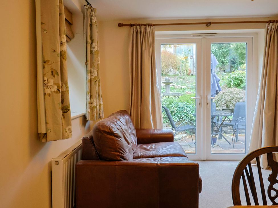A living room with a sofa and a view of the garden at Coombe Cottage Apartment Axmouth