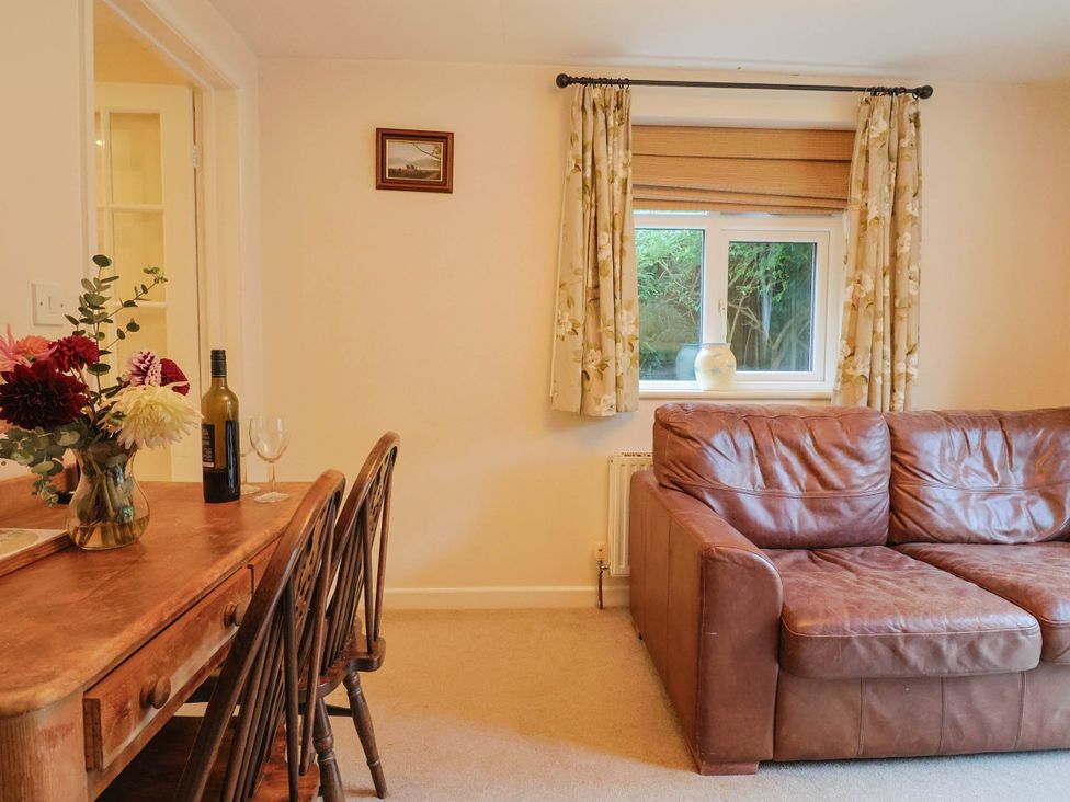 A living room with a table and sofa at Coombe Cottage Apartment in Axmouth