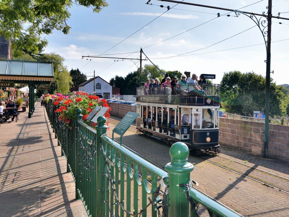An outdoor scene with a tram and flowers at Coombe Cottage Apartment Axmouth