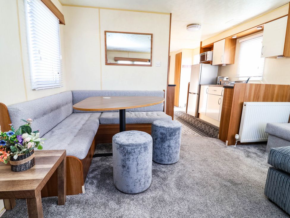 A living room with a sofa and table at Beach Fields 45 in Kinmel Bay
