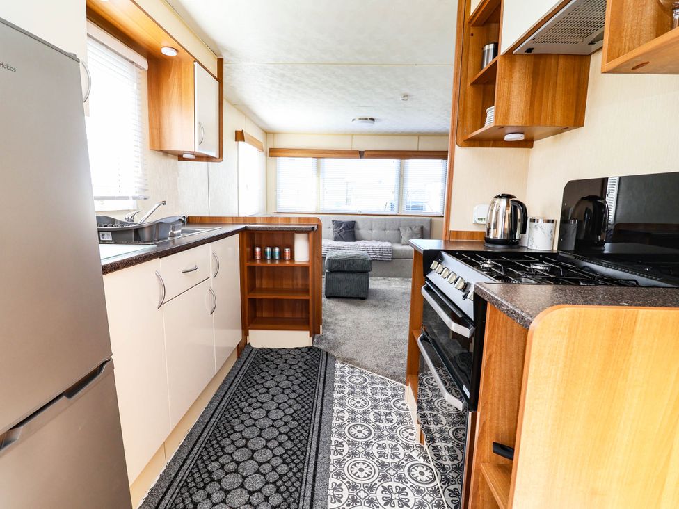 A kitchen with appliances and living area at Beach Fields 45 Kinmel Bay