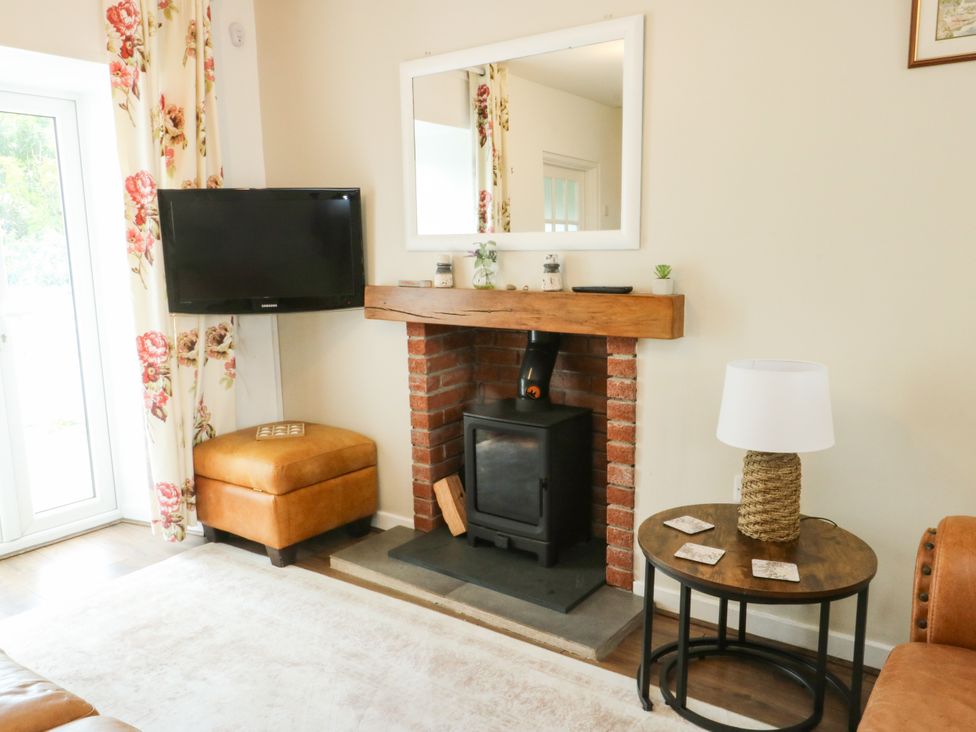 A living room with a fireplace and television at Mor Awelon in Moelfre