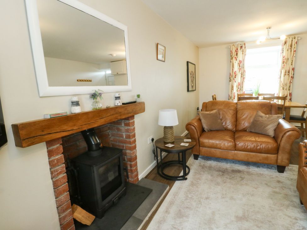 A living room with a sofa and fireplace at Mor Awelon in Moelfre