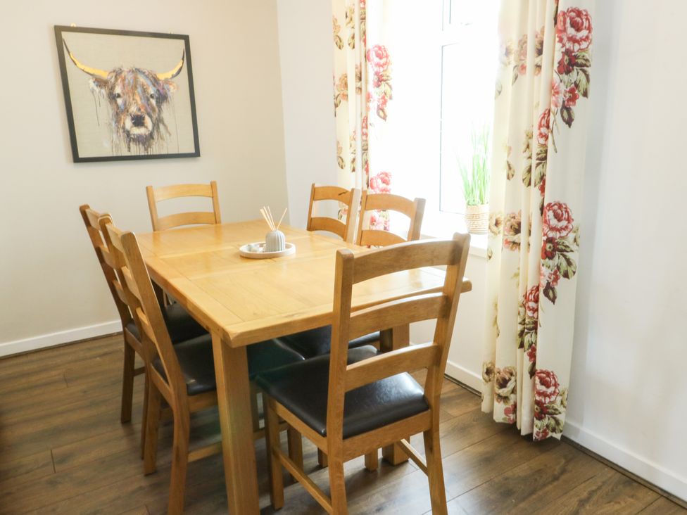 A dining room with a table and chairs at Mor Awelon in Moelfre
