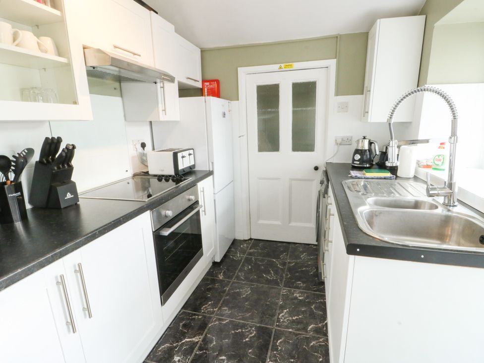 A kitchen with appliances and storage at Mor Awelon in Moelfre