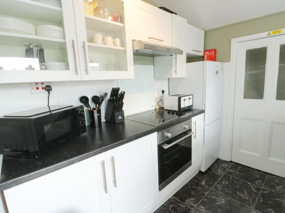 A kitchen with a microwave, oven, and refrigerator at Mor Awelon in Moelfre