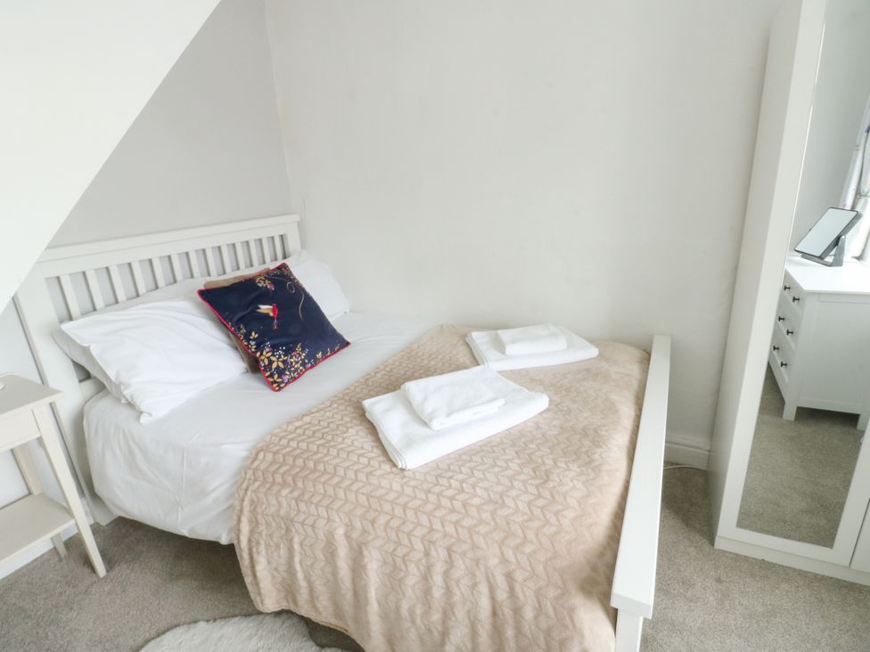 A bedroom with a bed and dressing table at Mor Awelon in Moelfre