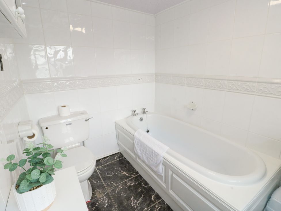 A bathroom with a bathtub and toilet at Mor Awelon in Moelfre
