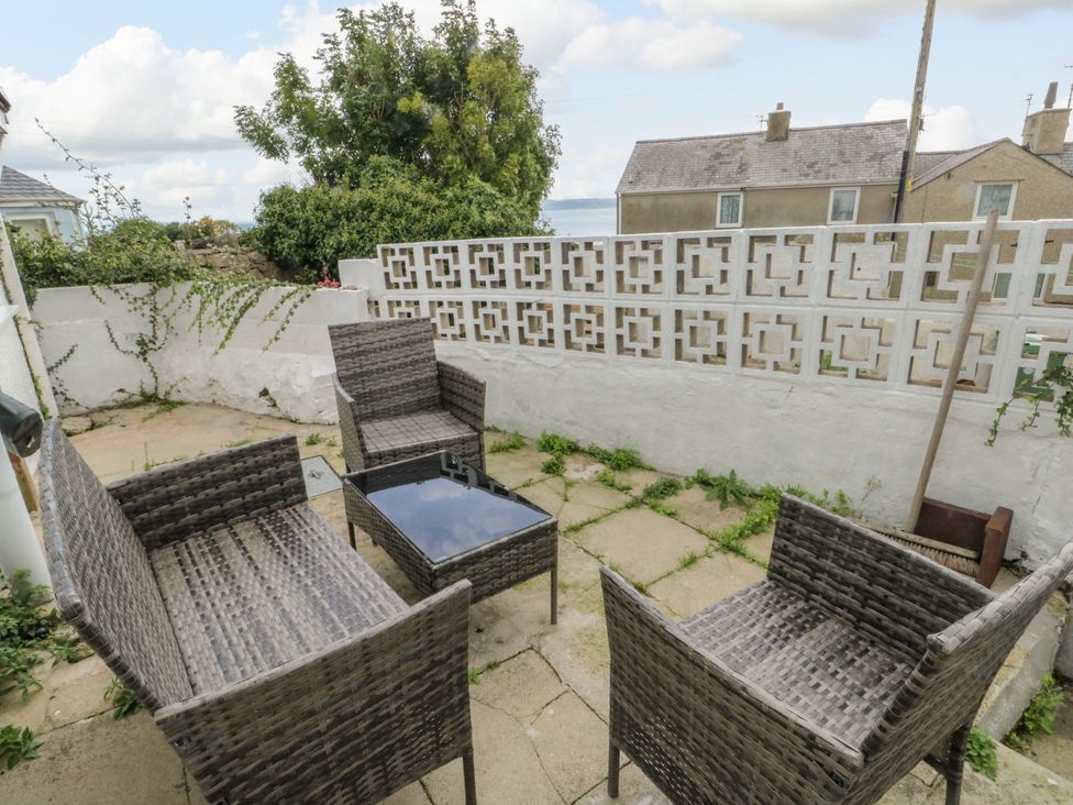 A garden with outdoor seating and a table at Mor Awelon in Moelfre