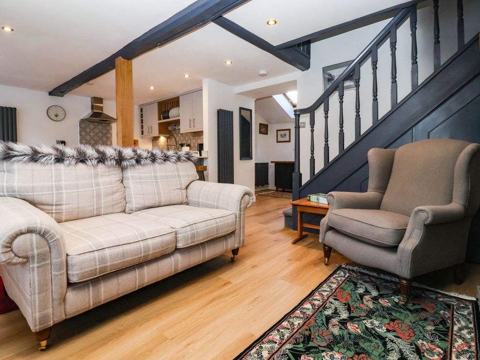 A living room with a sofa and armchair at Winksey Cottage in Harrogate