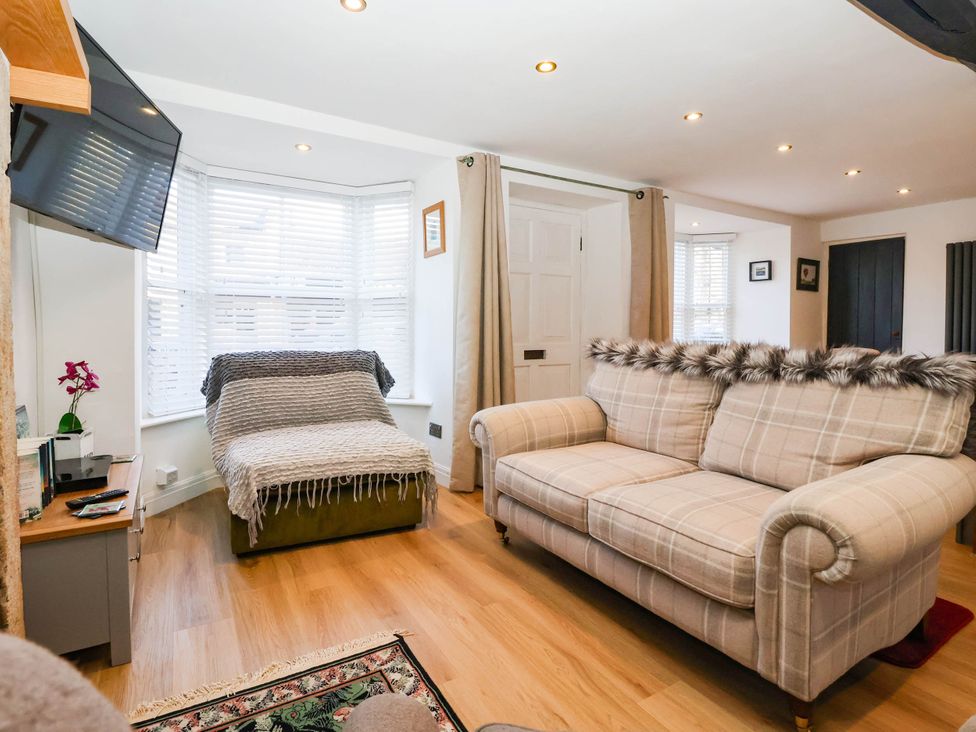 A living room with a sofa and television at Winksey Cottage in Harrogate