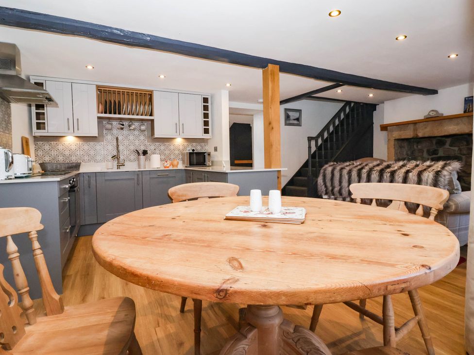 A kitchen with a dining table and chairs at Winksey Cottage in Harrogate